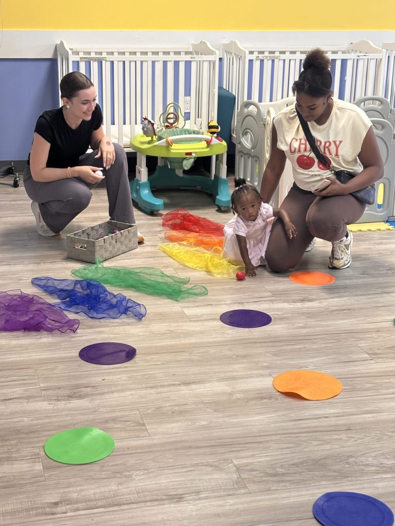 Infant room play time with rainbow scarves