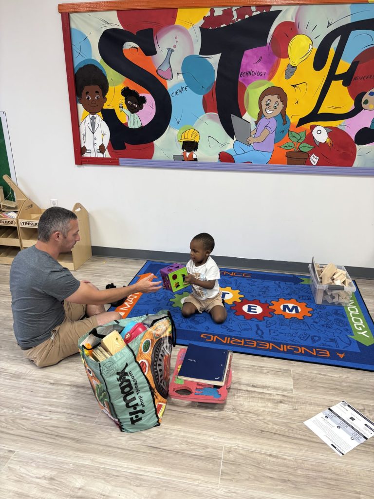 Teacher and toddler playing with a shape sorter